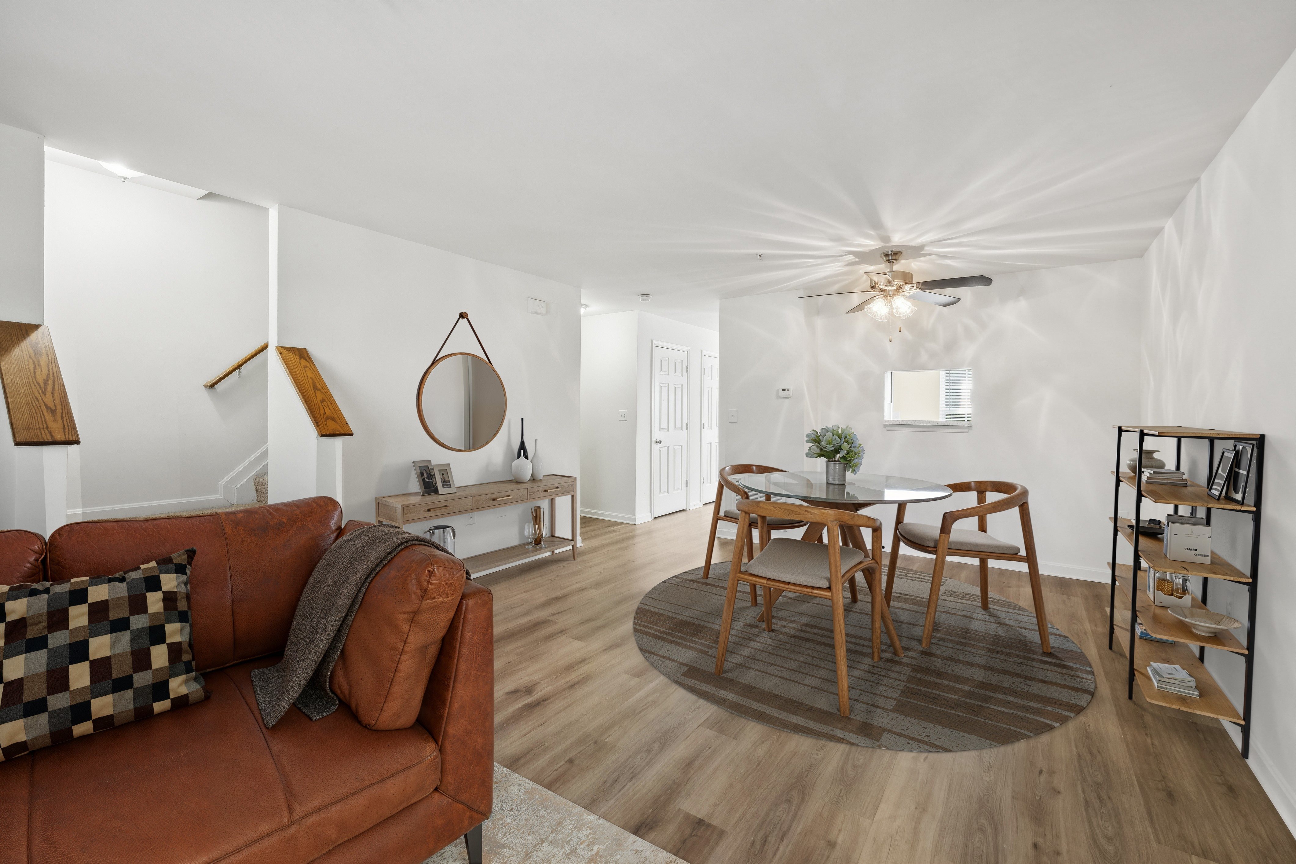 A living room with a brown couch and a wooden table.